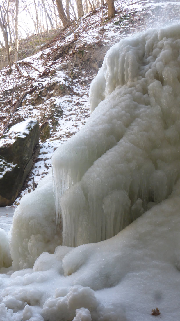 Winter ice mound below waterfall