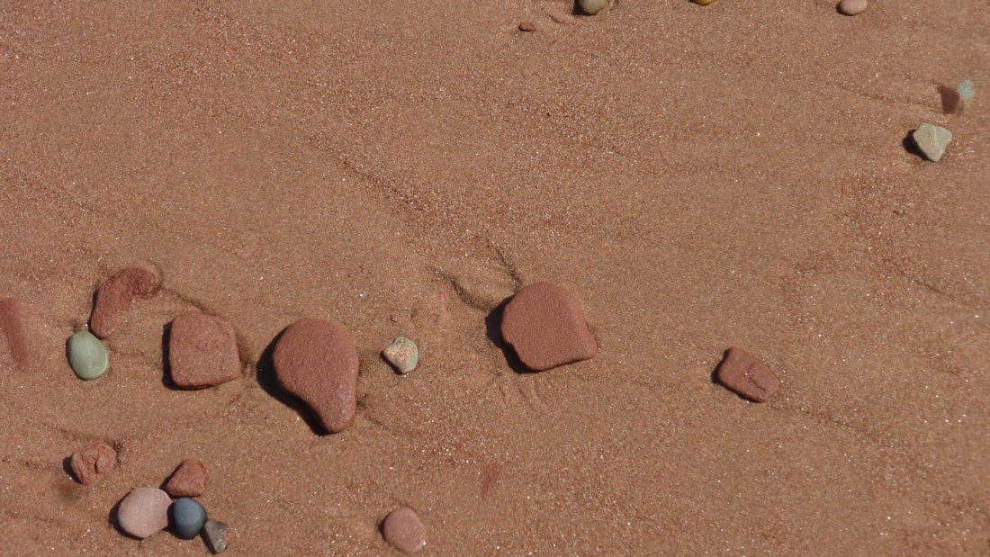 Pebbles on red beach sand